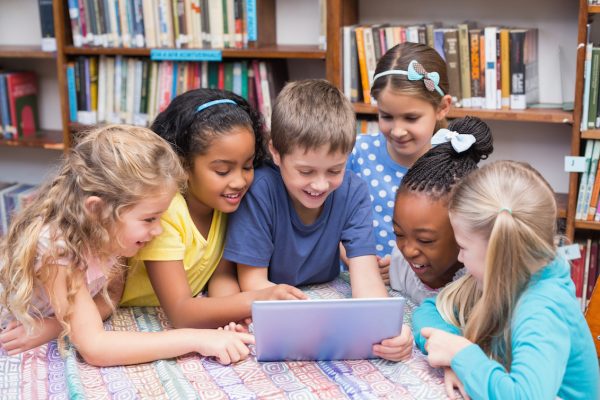 Cute pupils looking at tablet in library at the elementary school; Shutterstock ID 210167305; projeto: 0000000; Job: CO EF 04 AZUL 91 4B LV 09 MI DMUL PR _ DHIS G120; Client: editora; Other: Maiti Salla